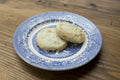 Two round cookies on a wooden cutting board
